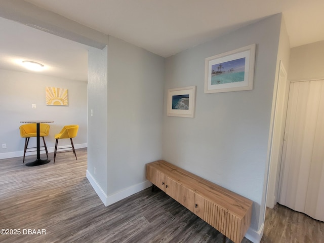 corridor with wood finished floors and baseboards