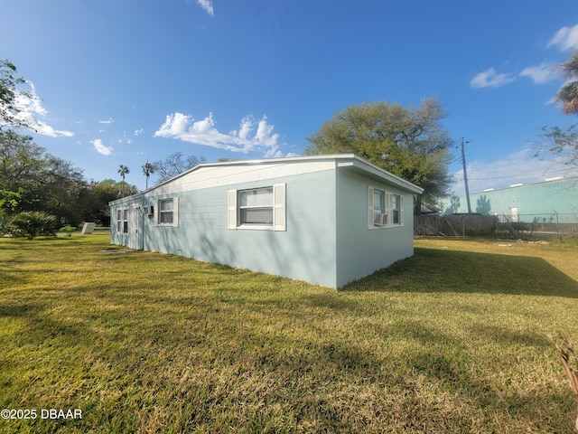 view of home's exterior featuring fence and a lawn