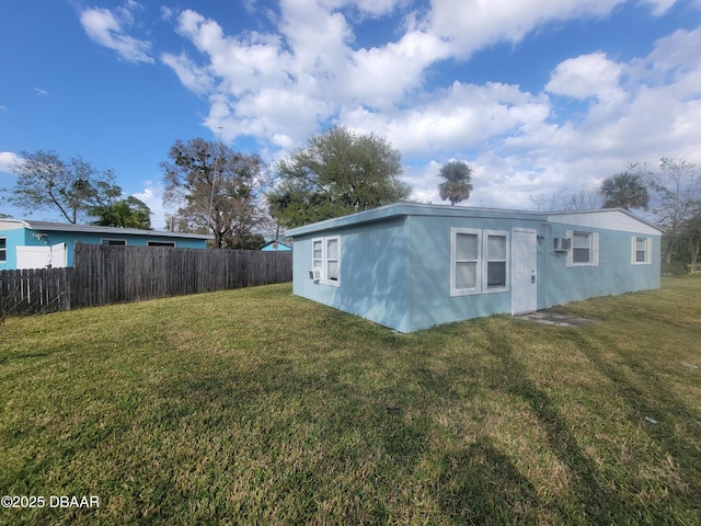 view of outbuilding featuring an AC wall unit and fence