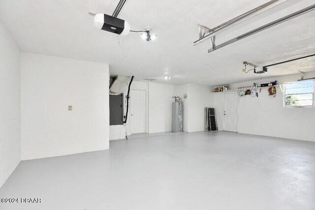 garage featuring heating unit, water heater, and a garage door opener