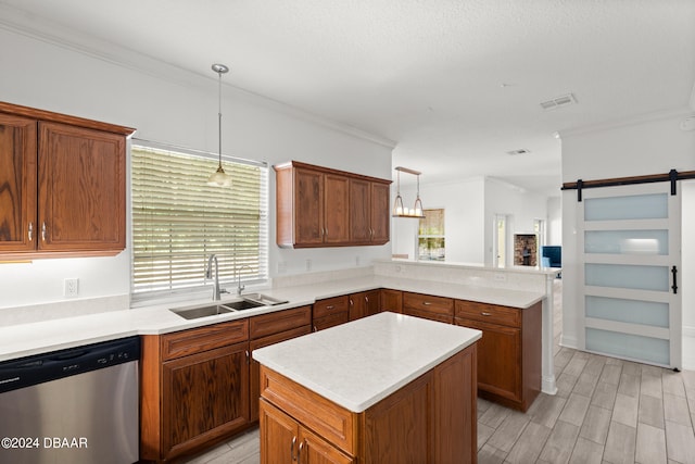 kitchen featuring sink, a kitchen island, a barn door, pendant lighting, and dishwasher