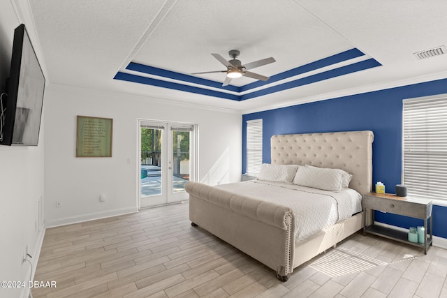 bedroom featuring ceiling fan, a textured ceiling, access to exterior, light wood-type flooring, and french doors