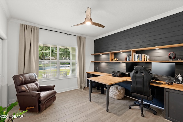 office space with light hardwood / wood-style floors, ceiling fan, wooden walls, and crown molding