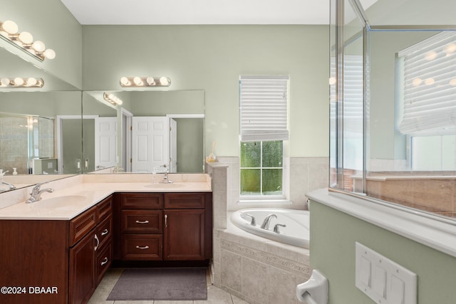 bathroom featuring shower with separate bathtub, vanity, and tile patterned floors