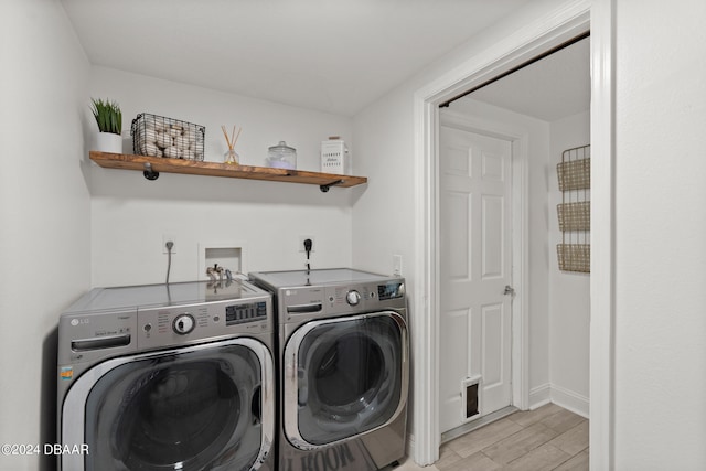 laundry area featuring washing machine and dryer and light wood-type flooring