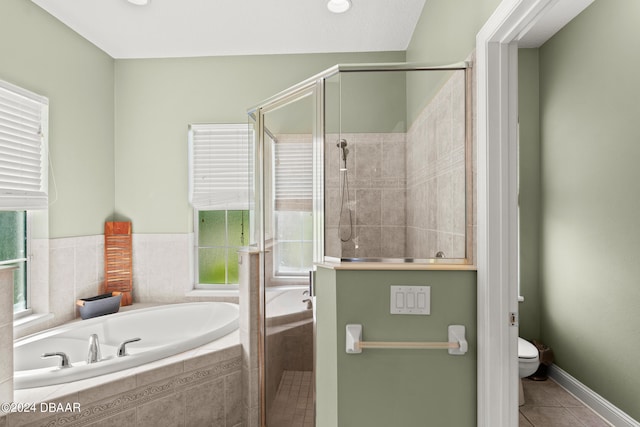 bathroom with toilet, independent shower and bath, a wealth of natural light, and tile patterned floors