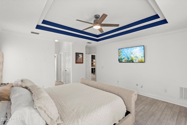 bedroom with ornamental molding, light hardwood / wood-style floors, and ceiling fan