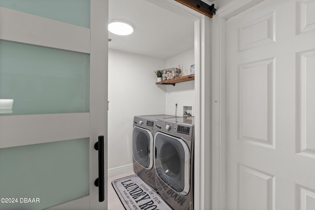 laundry room featuring a barn door and washer and clothes dryer