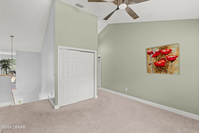 unfurnished bedroom featuring ceiling fan, a closet, lofted ceiling, and carpet floors