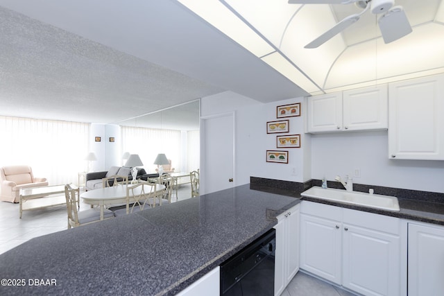 kitchen with dark countertops, open floor plan, a sink, ceiling fan, and dishwasher