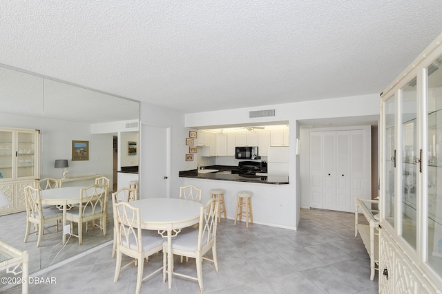 dining room featuring visible vents and a textured ceiling