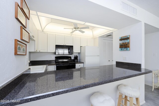 kitchen with visible vents, white cabinets, a ceiling fan, a peninsula, and black appliances