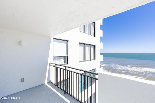 balcony featuring a beach view and a water view