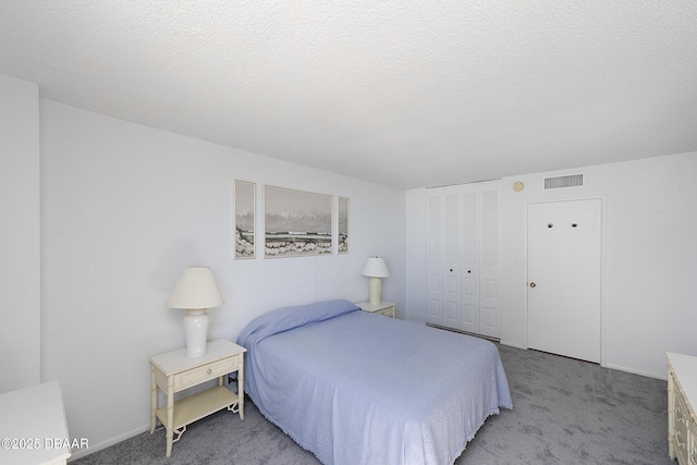 bedroom featuring a textured ceiling, a closet, visible vents, and light colored carpet