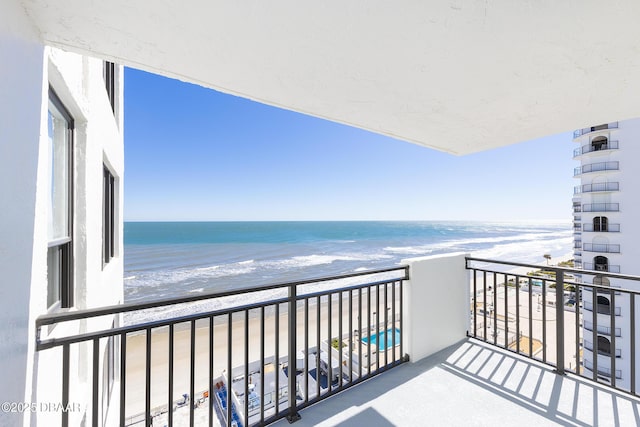 balcony featuring a water view and a view of the beach