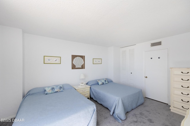 bedroom with a textured ceiling, a closet, visible vents, and light colored carpet