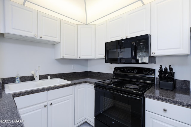 kitchen with dark countertops, black appliances, white cabinetry, and a sink