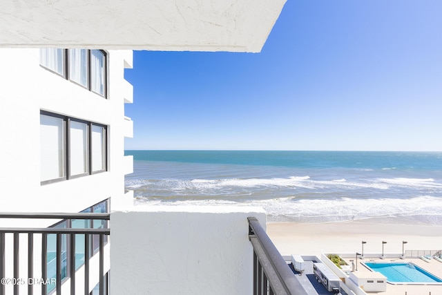 balcony with a water view and a beach view