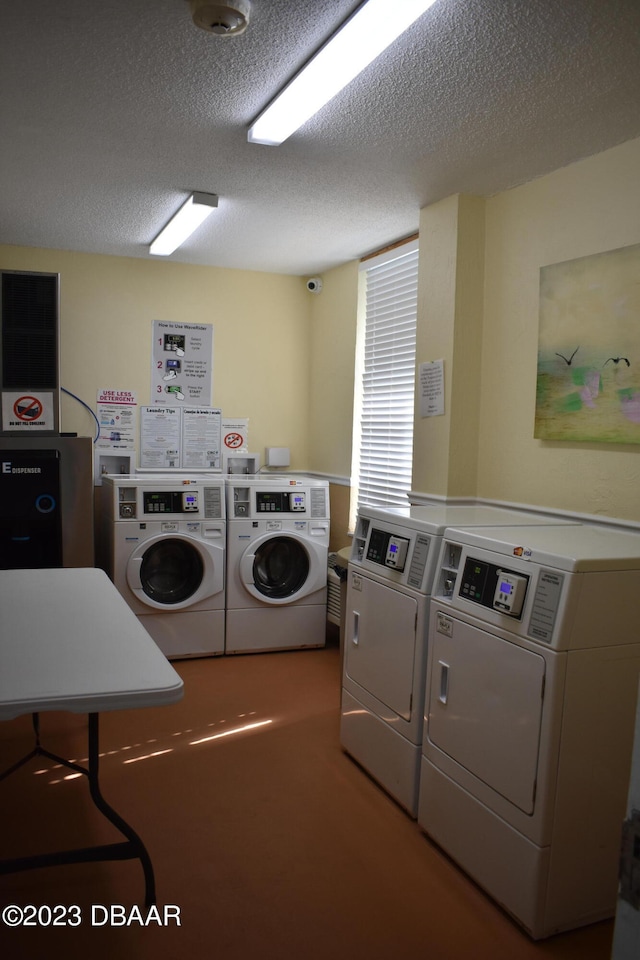 laundry area featuring a textured ceiling and washer and clothes dryer