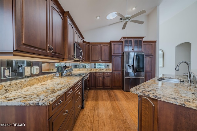 kitchen featuring appliances with stainless steel finishes, sink, light wood-type flooring, and dark brown cabinets