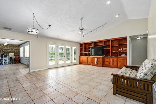 living room featuring french doors, ceiling fan with notable chandelier, vaulted ceiling, a textured ceiling, and light tile patterned floors