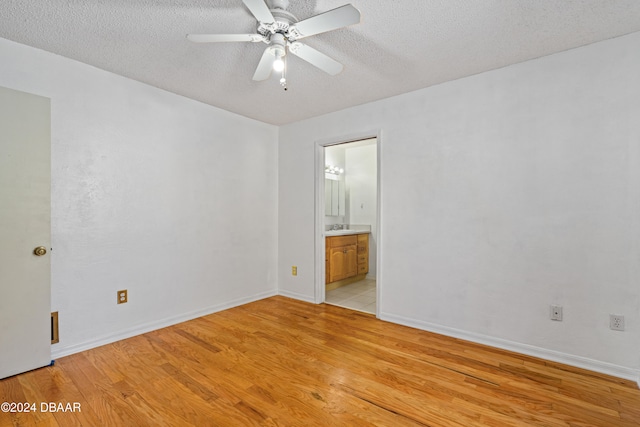 unfurnished room featuring light hardwood / wood-style flooring, a textured ceiling, ceiling fan, and sink