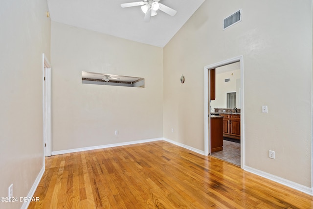 spare room featuring light hardwood / wood-style floors, ceiling fan, and high vaulted ceiling