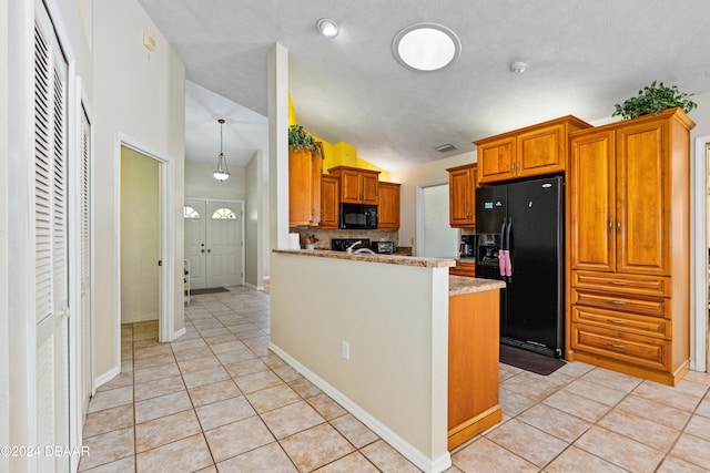 kitchen with a textured ceiling, kitchen peninsula, black appliances, and light tile patterned floors