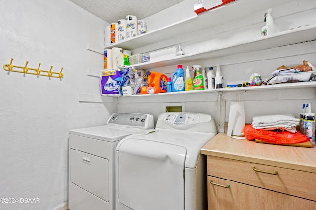 laundry room featuring washing machine and dryer and a textured ceiling