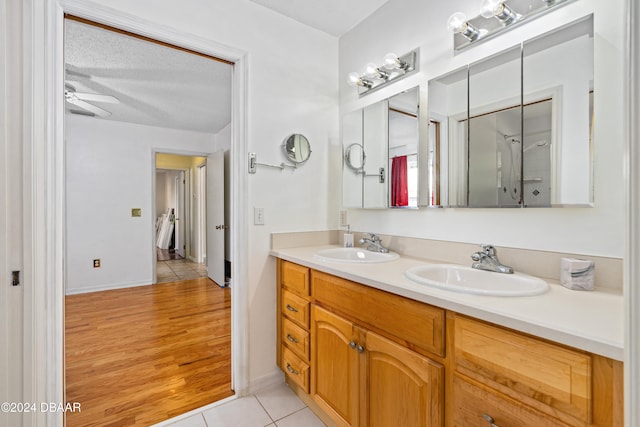 bathroom featuring hardwood / wood-style floors, ceiling fan, vanity, and a textured ceiling