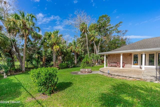 view of yard featuring an outdoor fire pit and a patio area