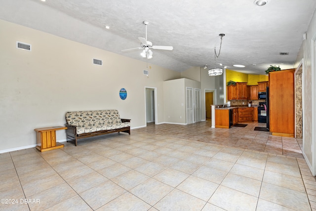 kitchen with ceiling fan with notable chandelier, hanging light fixtures, a textured ceiling, and light tile patterned floors