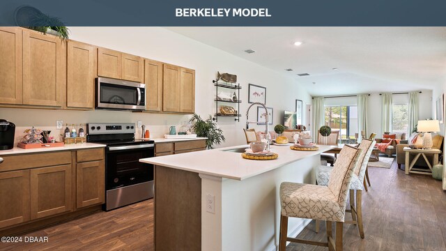 kitchen with stainless steel appliances, a kitchen bar, dark hardwood / wood-style floors, sink, and an island with sink