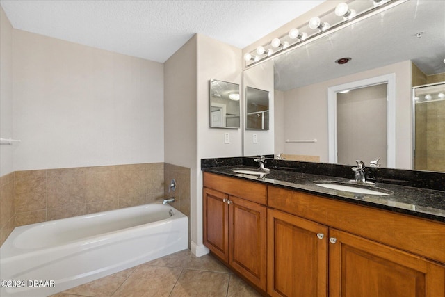 bathroom with tile patterned flooring, vanity, a textured ceiling, and separate shower and tub