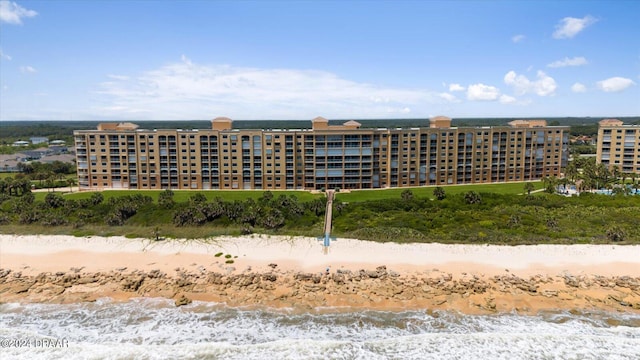 view of building exterior featuring a beach view and a water view