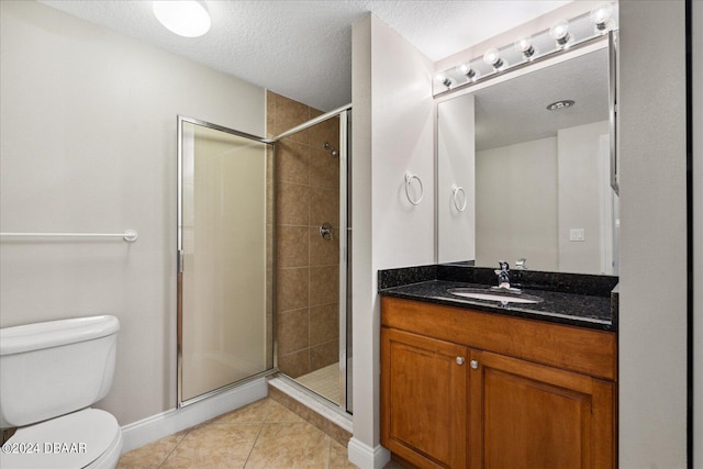 bathroom with toilet, tile patterned floors, a textured ceiling, vanity, and walk in shower