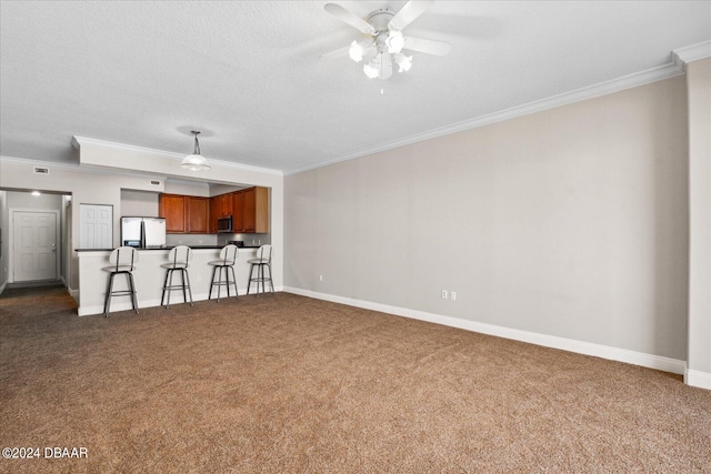 unfurnished living room with ceiling fan, a textured ceiling, carpet, and ornamental molding