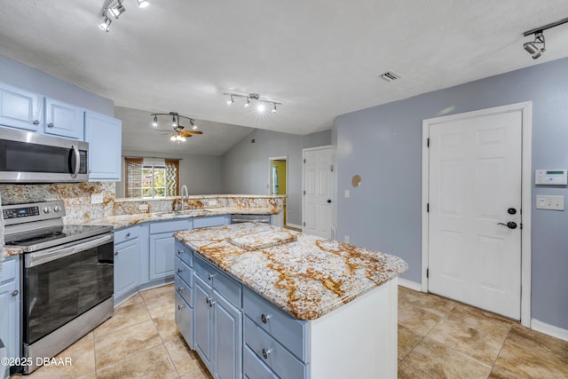 20 Potters Ln, Palm Coast, FL 32164 - kitchen featuring appliances with stainless steel finishes, rail lighting, a peninsula, a kitchen island, and a sink