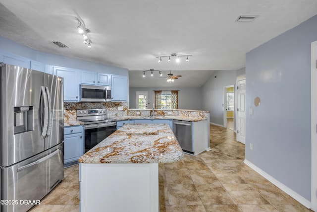 20 Potters Ln, Palm Coast, FL 32164 - kitchen featuring stainless steel appliances, a peninsula, tasteful backsplash, a center island, and light stone counters