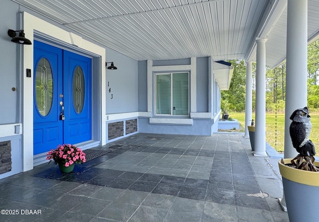 view of exterior entry featuring stucco siding and covered porch