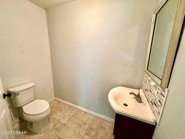 half bath with tile patterned floors, vanity, and toilet