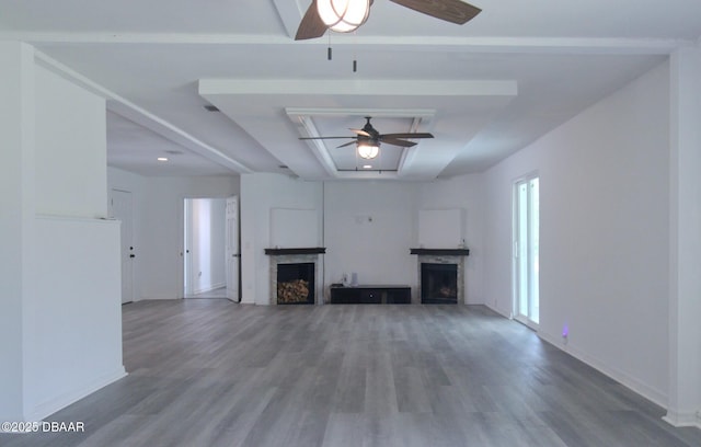 unfurnished living room with a ceiling fan, wood finished floors, and a fireplace