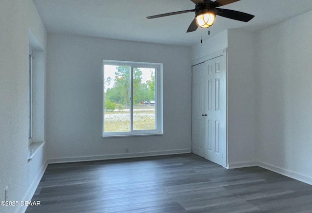 unfurnished bedroom with baseboards, ceiling fan, wood finished floors, and a closet