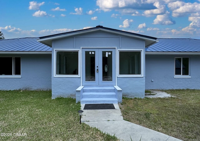 view of front of house featuring french doors, a standing seam roof, metal roof, and a front yard