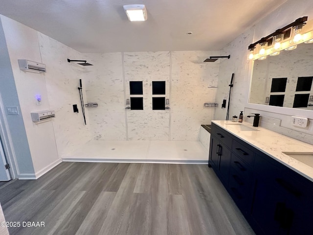 bathroom with a sink, a walk in shower, double vanity, and wood finished floors