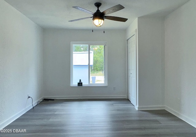spare room featuring baseboards, a ceiling fan, and wood finished floors