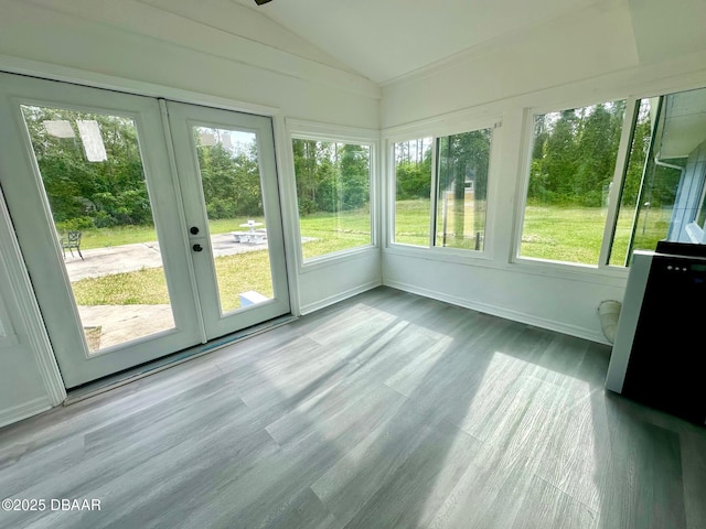 unfurnished sunroom with plenty of natural light, french doors, wood finished floors, and lofted ceiling