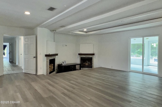 unfurnished living room with visible vents, recessed lighting, wood finished floors, and a fireplace