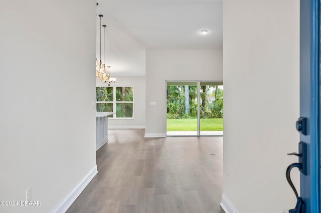 hallway featuring light hardwood / wood-style flooring and a notable chandelier