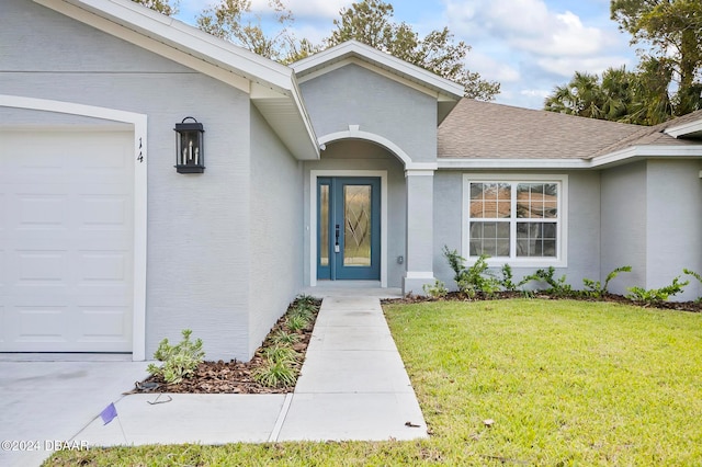 property entrance featuring a garage and a yard